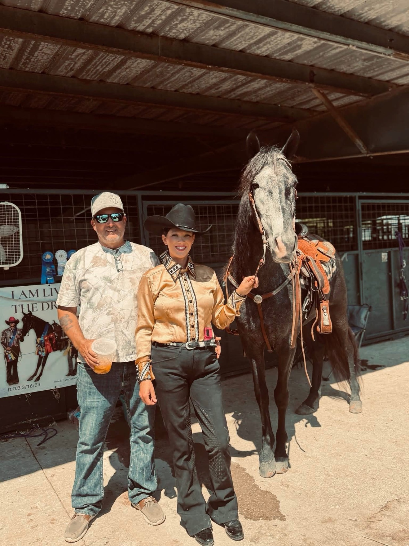 Hayley and a man standing beside a saddled horse at a horse show