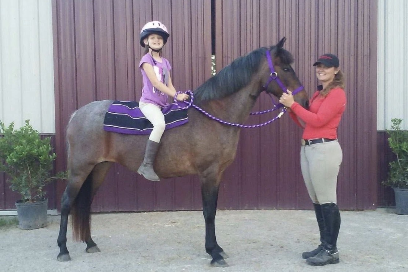 Hayley Stables customers with a purchased horse at an arena