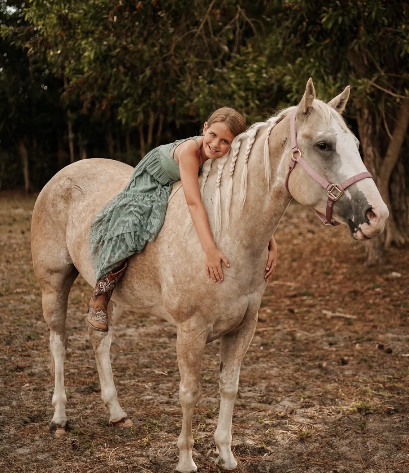A young Hayley Stables customer hugging her purchased gray horse